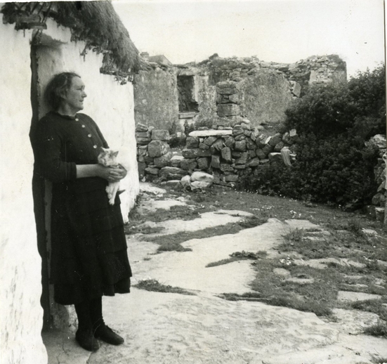 Maggie Dirrane (1899-1995) at her back door in Eoghanacht, Árainn, August 1956, courtesy of the Ralph Rinzler Folklife Archives and Collections / Sidney Robertson Cowell
